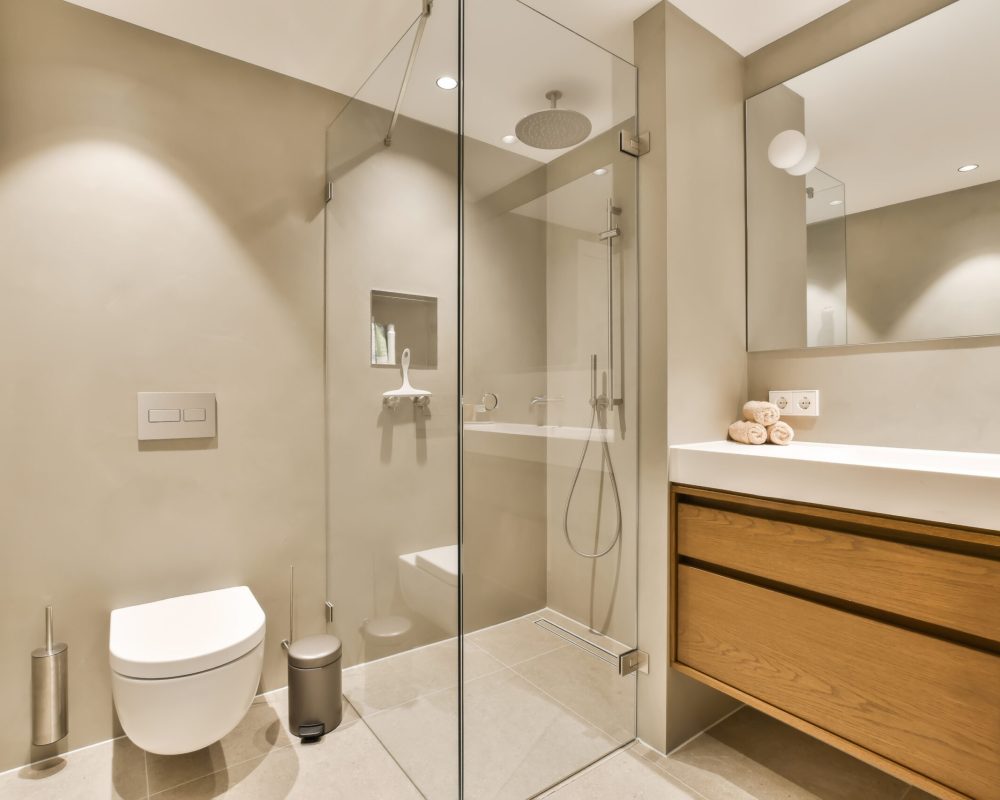 Dusjvegg i glass på moderne baderom med lyse fliser og naturlig lys